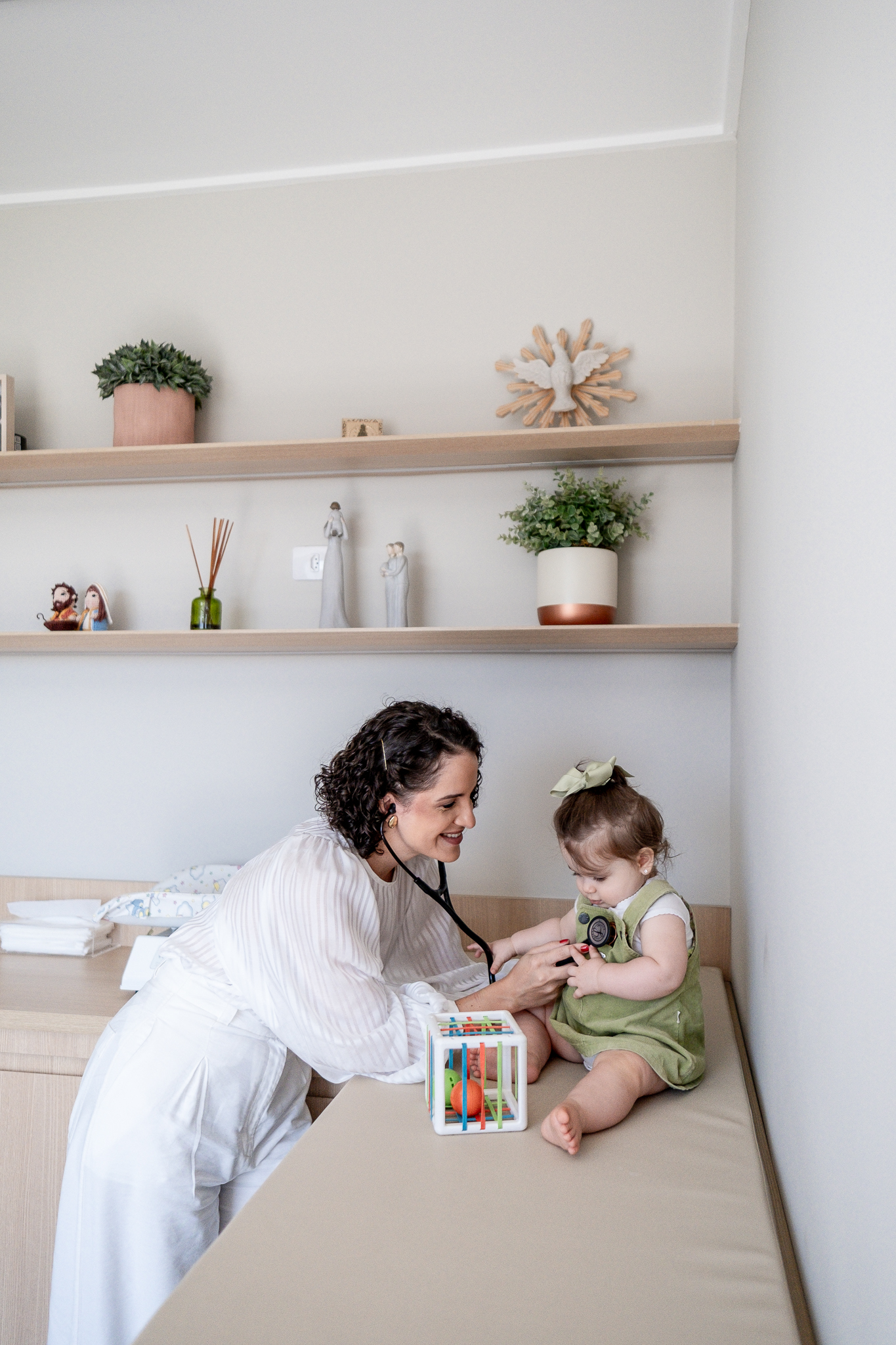 Dra. Paula examinando um bebê com carinho durante a consulta