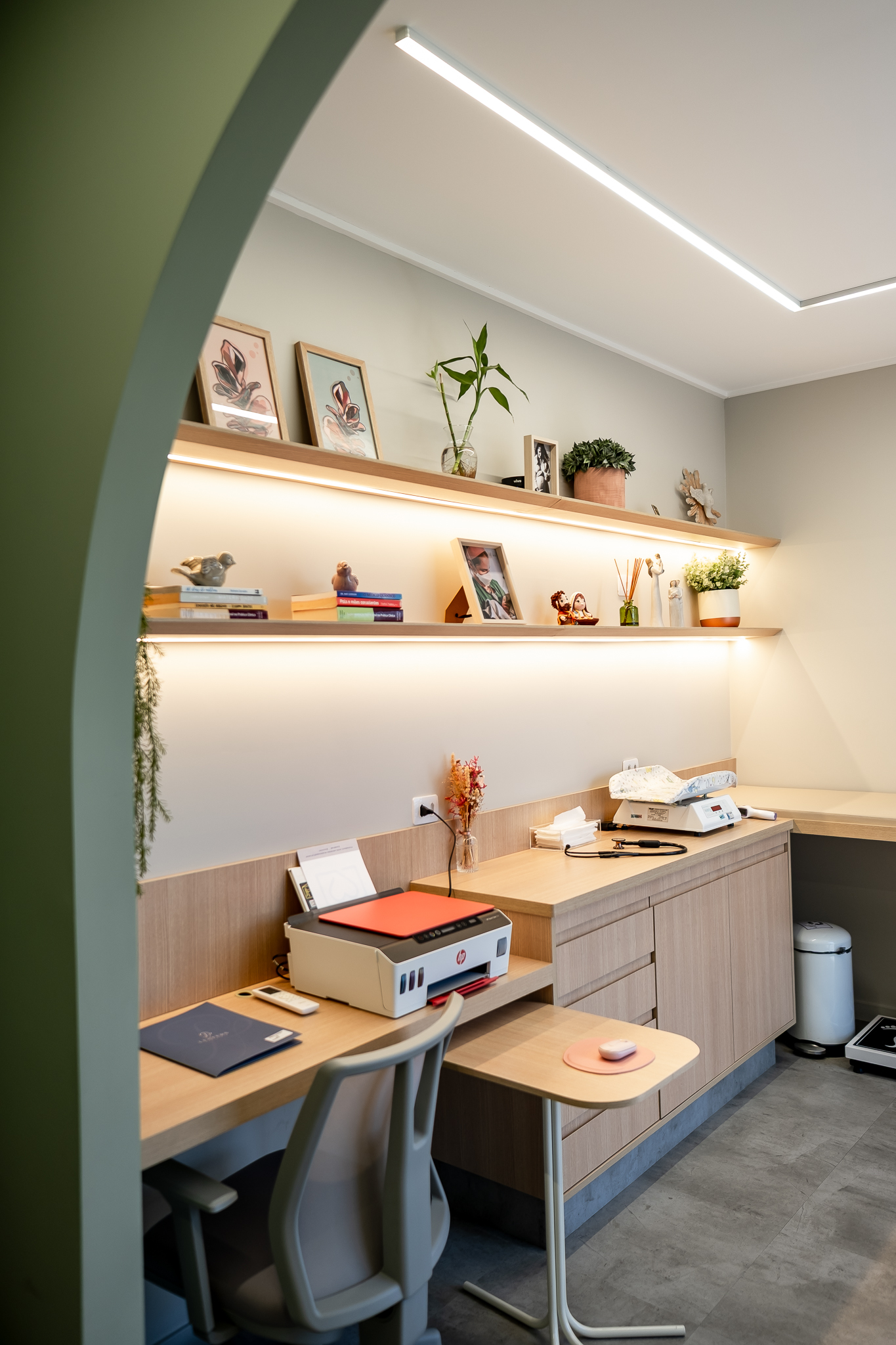 Consultório com estantes decoradas e espaço de trabalho